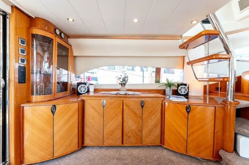 Jugni Yacht Photos Pics Luxurious interior of 2003 Viking Princess 65 yacht with elegant wood cabinetry and modern staircase.