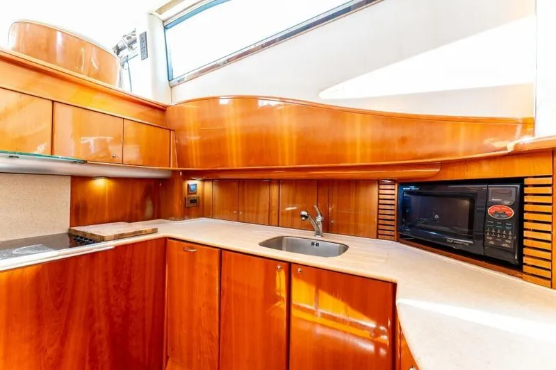Jugni Yacht Photos Pics Luxurious 2003 Viking Princess 65 yacht kitchen with sleek wood cabinetry and modern appliances.