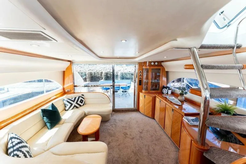 Jugni Yacht Photos Pics Luxurious interior of 2003 Viking Princess 65 yacht with elegant seating and wooden cabinetry.
