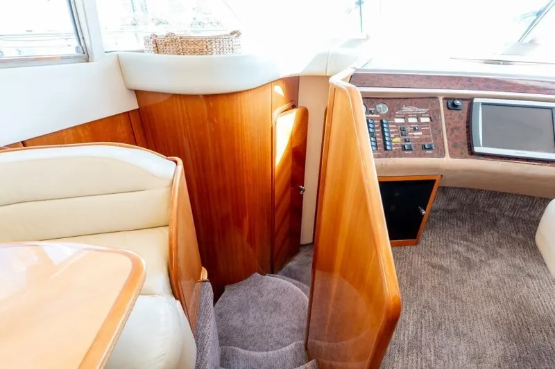 Jugni Yacht Photos Pics Luxurious interior of 2003 Viking Princess 65 yacht with wood paneling and control panel.