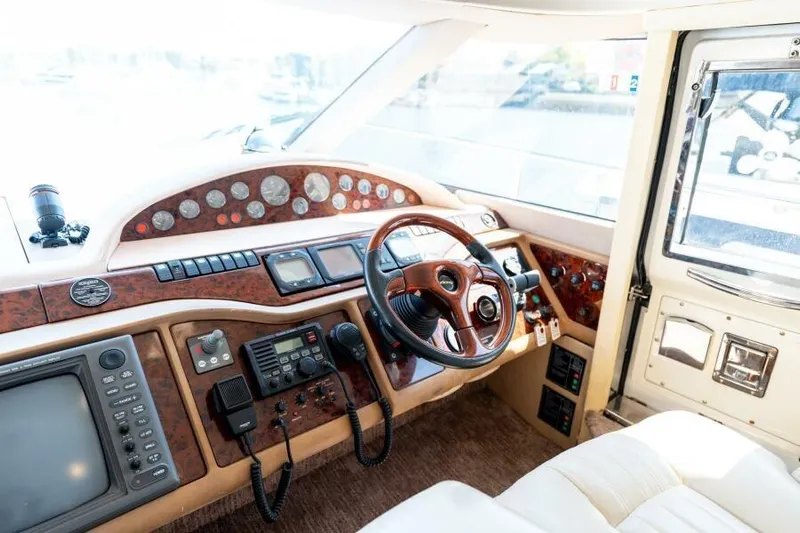 Jugni Yacht Photos Pics Luxurious 2003 Viking Princess 65 yacht helm with wood accents and advanced navigation controls.