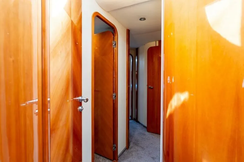 Jugni Yacht Photos Pics Interior hallway of 2003 Viking Princess 65 yacht with wooden doors and carpeted floor.