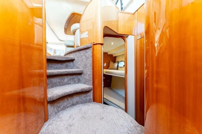 Jugni Yacht Photos Pics Luxurious interior of 2003 Viking Princess 65 yacht with carpeted stairs and wooden finish.