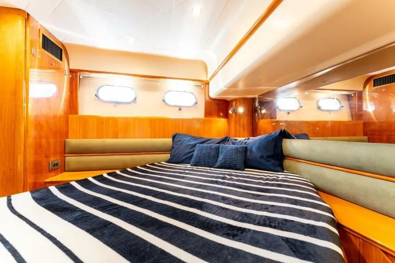 Jugni Yacht Photos Pics Luxurious cabin interior of 2003 Viking Princess 65 yacht with striped bedding.