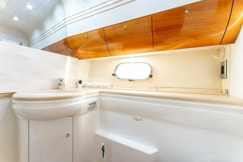 Jugni Yacht Photos Pics Luxurious bathroom interior of 2003 Viking Princess 65 yacht with wooden cabinets and modern fixtures.