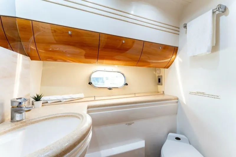Jugni Yacht Photos Pics Luxurious bathroom in 2003 Viking Princess 65 yacht with elegant wood cabinetry and modern fixtures.