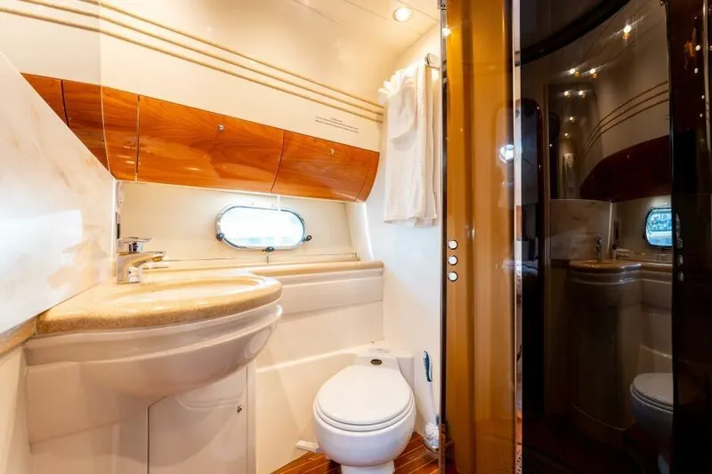 Jugni Yacht Photos Pics Luxurious bathroom in 2003 Viking Princess 65 yacht with elegant wood accents and modern fixtures.