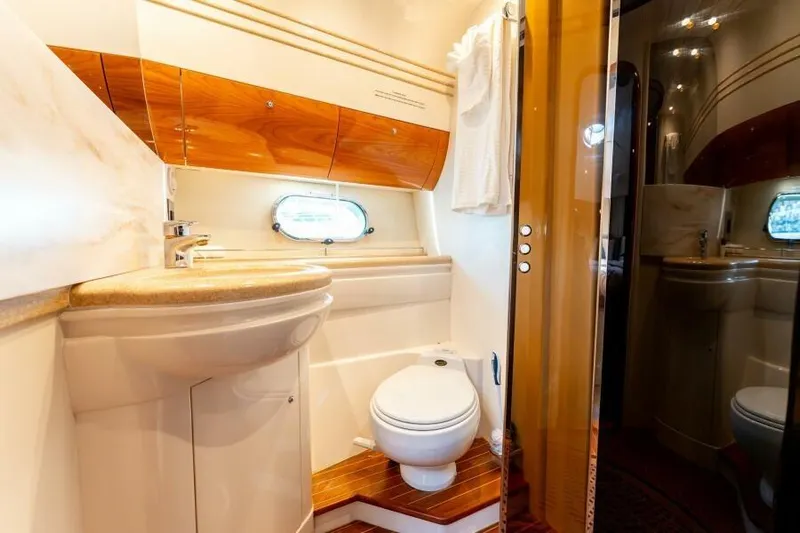 Jugni Yacht Photos Pics Luxurious bathroom in 2003 Viking Princess 65 yacht with elegant wood accents and modern fixtures.