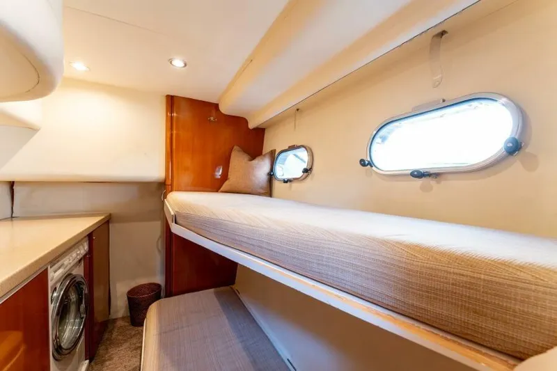 Jugni Yacht Photos Pics Luxurious 2003 Viking Princess 65 yacht cabin with bunk beds and porthole windows.