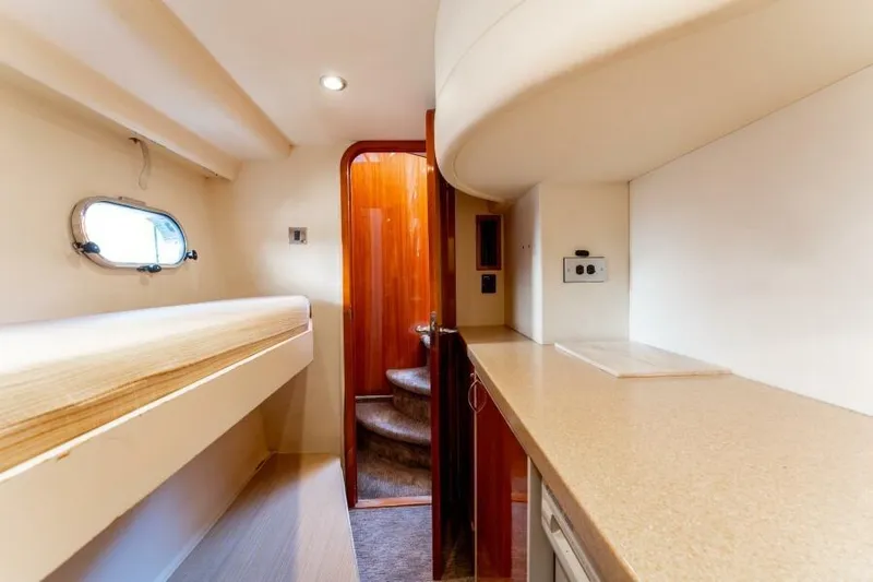 Jugni Yacht Photos Pics Interior of 2003 Viking Princess 65 yacht with bunk bed and wooden stairs.