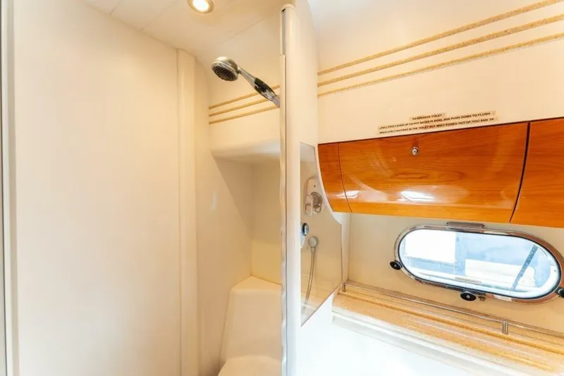 Jugni Yacht Photos Pics Luxurious bathroom interior of 2003 Viking Princess 65 yacht with shower and porthole.