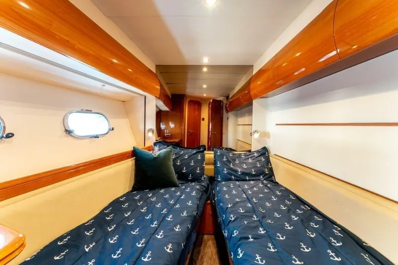 Jugni Yacht Photos Pics Luxurious cabin interior of 2003 Viking Princess 65 yacht with twin beds and nautical decor.