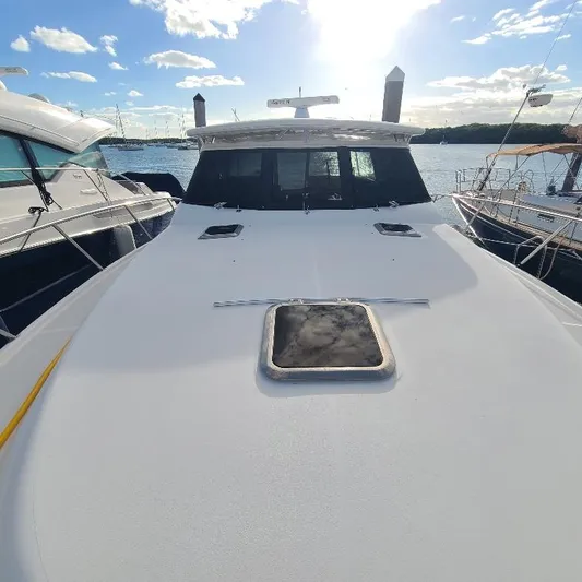 Blue Meridian Yacht Photos Pics 2003 Tiara Yachts 3800 Open on water, sunny day, docked with other boats.