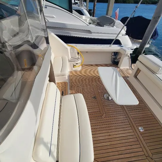 Blue Meridian Yacht Photos Pics 2003 Tiara Yachts 3800 Open with teak deck and seating, docked by the water.