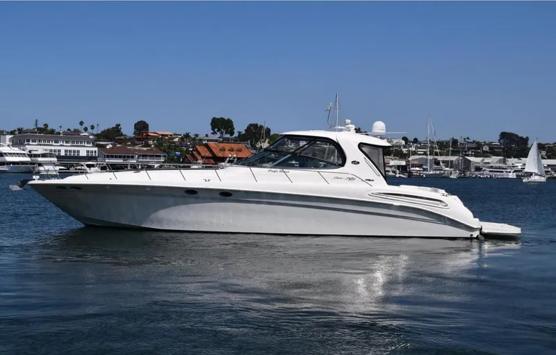 Pacific Dancer Yacht Photos Pics 2004 Sea Ray 550 Sundancer yacht on calm water, with coastal background.