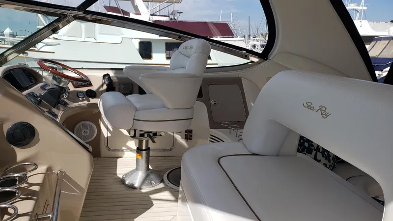 Pacific Dancer Yacht Photos Pics 2004 Sea Ray 550 Sundancer yacht interior with white leather seating and helm controls.