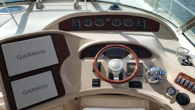 Pacific Dancer Yacht Photos Pics Helm of 2004 Sea Ray 550 Sundancer with Garmin navigation displays and wood-accented steering wheel.