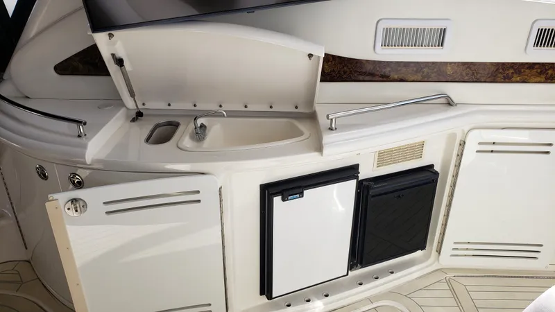 Pacific Dancer Yacht Photos Pics 2004 Sea Ray 550 Sundancer yacht kitchenette with sink, storage, and mini fridge.