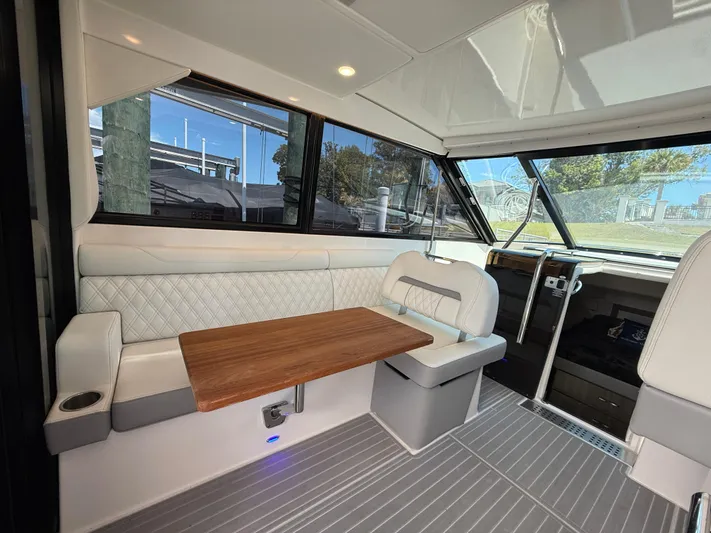  Yacht Photos Pics Interior of 2022 Regal 36 Grande Coupe with seating and wooden table.