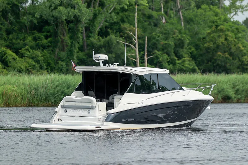  Yacht Photos Pics 2022 Regal 36 Grande Coupe cruising on a serene river with lush greenery.