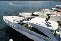 Luxury Pershing 65 yacht from 2001 docked in a serene marina setting.
