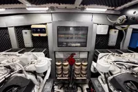 Engine room of a 2001 Pershing 65 yacht, featuring mechanical components and control panels.