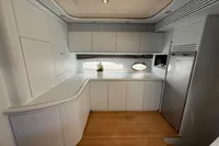 Interior of 2001 Pershing 65 yacht with modern white cabinetry and wood flooring.