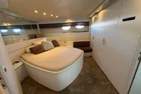 Luxurious bedroom interior of 2001 Pershing 65 yacht with plush bedding and modern design.