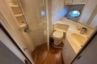 Bathroom interior of 2001 Pershing 65 yacht with shower, toilet, and sink.