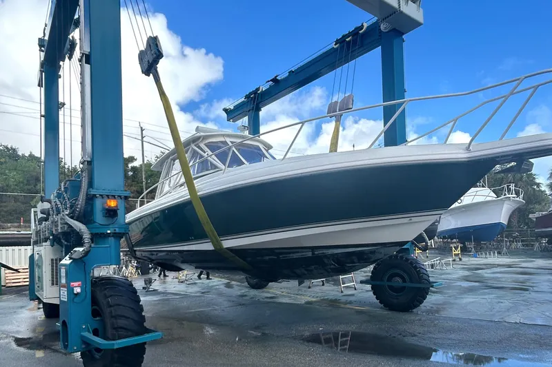 Summit Yacht Photos Pics 2004 Intrepid 377 Walkaround boat being lifted by a large crane in a shipyard.