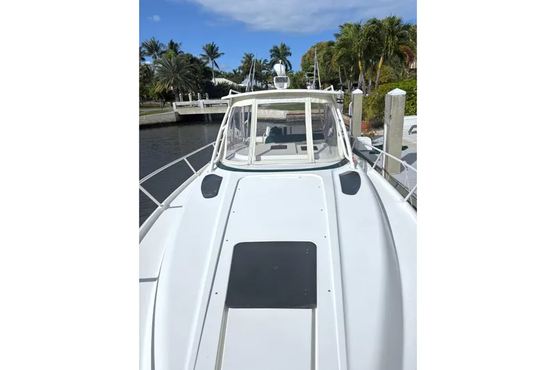 Summit Yacht Photos Pics 2004 Intrepid 377 Walkaround boat docked near palm trees and clear skies.
