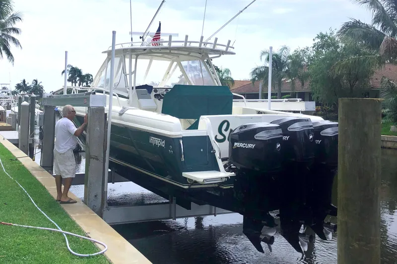 Summit Yacht Photos Pics 2004 Intrepid 377 Walkaround boat with Mercury engines on a lift by the dock.