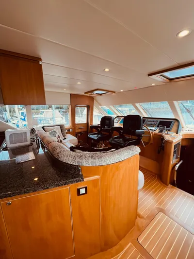 "conumdrum" Yacht Photos Pics Luxurious 2007 Regency Yachts 670 Pilothouse interior with elegant wood finishes and modern helm.