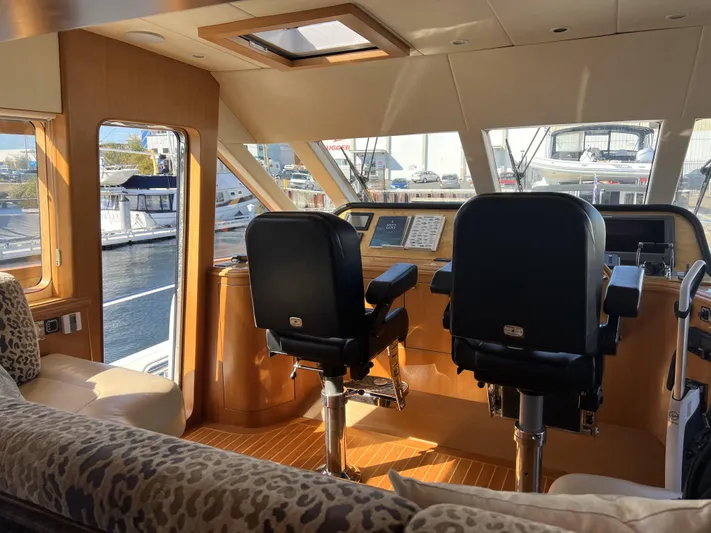 "conumdrum" Yacht Photos Pics 2007 Regency Yachts 670 Pilothouse interior helm with panoramic windows and plush seating.