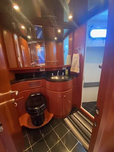 "conumdrum" Yacht Photos Pics Luxurious bathroom in a 2007 Regency Yachts 670 Pilothouse with wood cabinetry and modern fixtures.