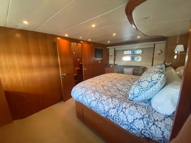 "conumdrum" Yacht Photos Pics Luxurious bedroom interior of 2007 Regency Yachts 670 Pilothouse with wood paneling and cozy bedding.