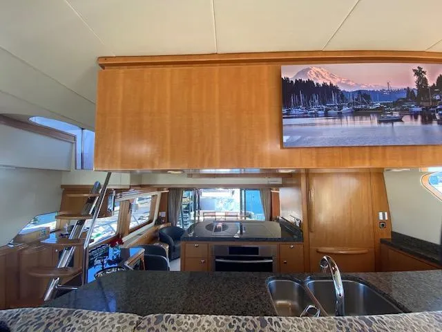 "conumdrum" Yacht Photos Pics Interior of 2007 Regency Yachts 670 Pilothouse with modern kitchen and wooden cabinetry.
