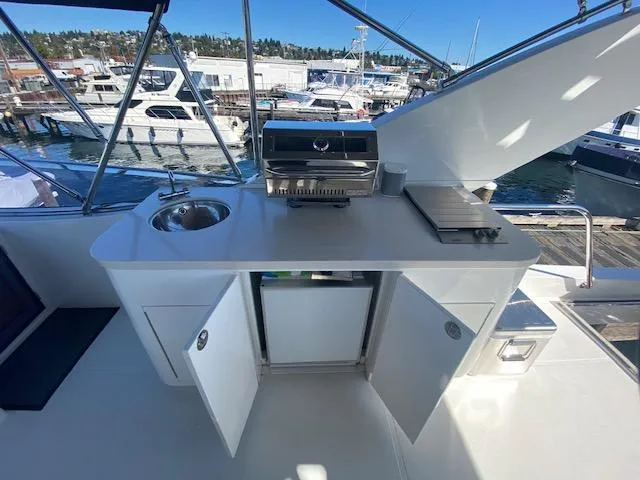 "conumdrum" Yacht Photos Pics Outdoor kitchen on 2007 Regency Yachts 670 Pilothouse with sink, grill, and storage.