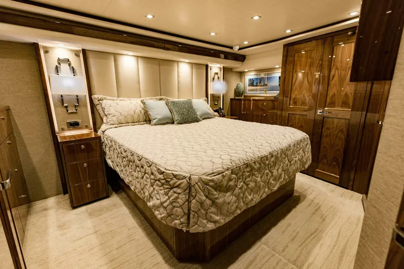 Sari Victoria Yacht Photos Pics Luxurious bedroom interior of 2020 Viking 72 yacht with elegant wood finishes and ambient lighting.