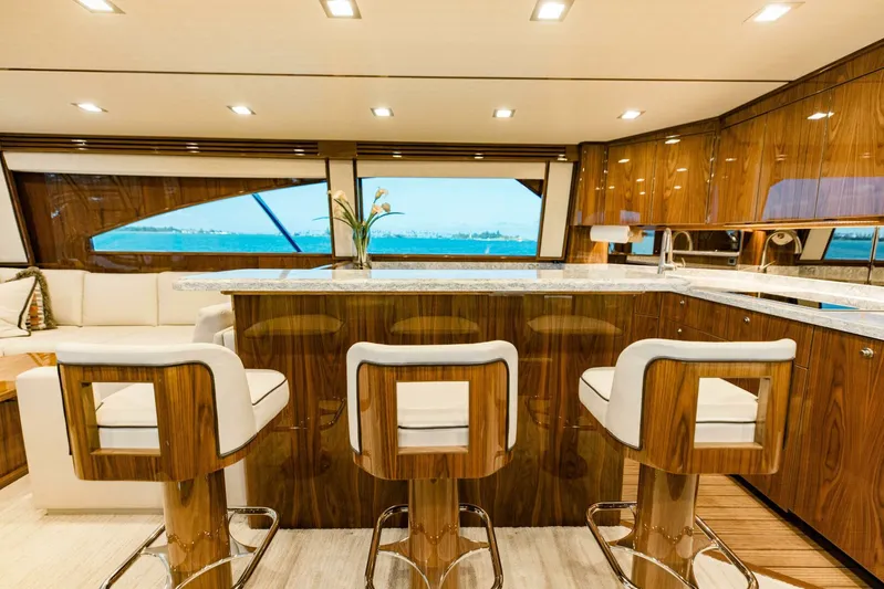 Sari Victoria Yacht Photos Pics Luxurious interior of 2020 Viking 72 yacht with elegant bar stools and panoramic windows.