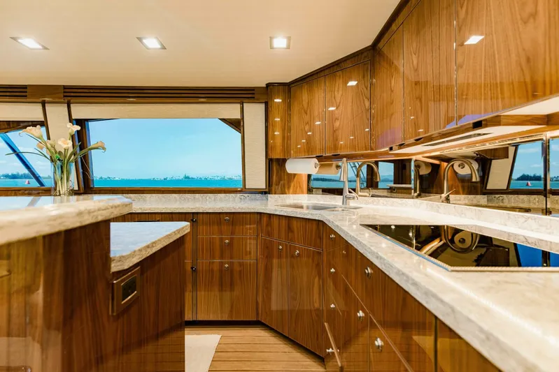 Sari Victoria Yacht Photos Pics Luxurious kitchen interior of 2020 Viking 72 yacht with wooden cabinetry and ocean view.