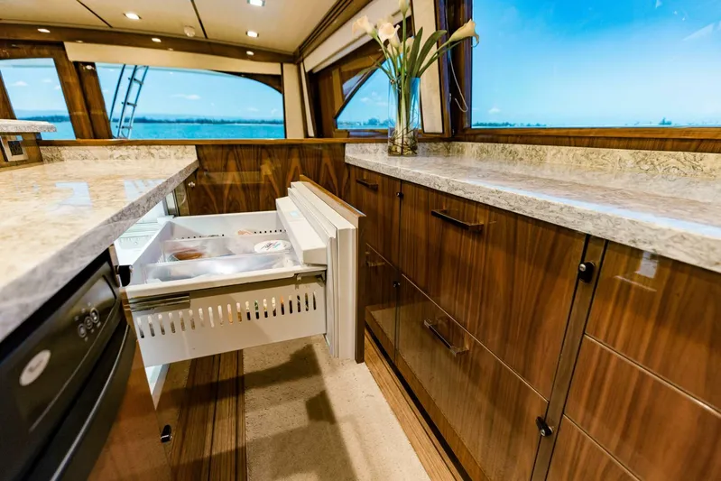Sari Victoria Yacht Photos Pics Luxurious Viking 72 yacht kitchen interior with open drawer, marble countertops, and ocean view.