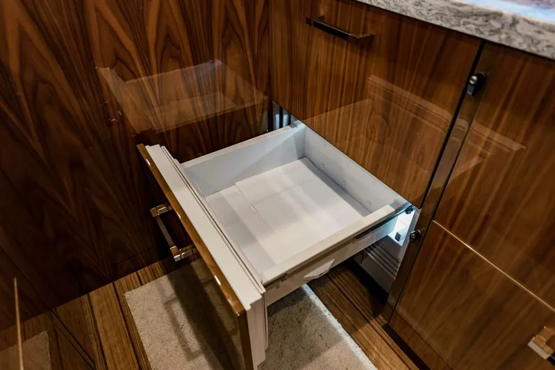 Sari Victoria Yacht Photos Pics Open drawer in a 2020 Viking 72 yacht's wooden cabinetry interior.
