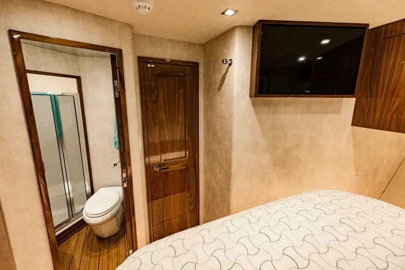Sari Victoria Yacht Photos Pics Interior of 2020 Viking 72 yacht cabin with bathroom and mounted TV.