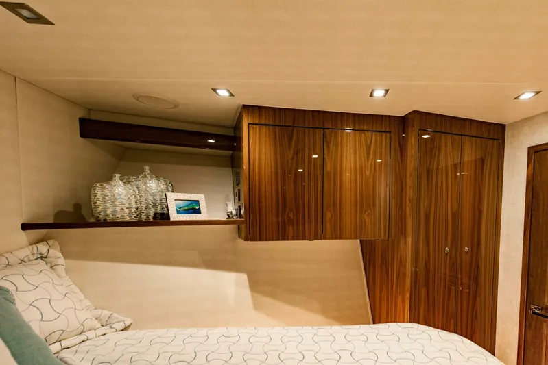 Sari Victoria Yacht Photos Pics Luxurious cabin interior of 2020 Viking 72 yacht with wooden cabinets and cozy bedding.