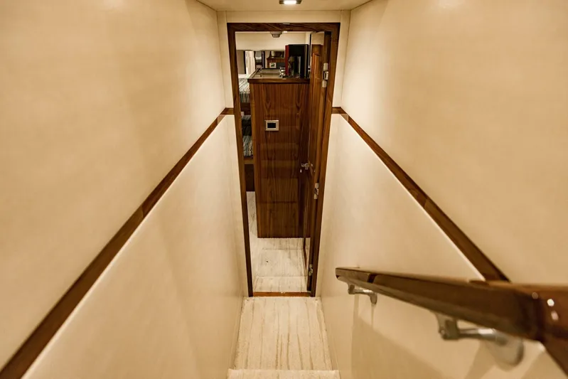 Sari Victoria Yacht Photos Pics Narrow hallway with wooden door and handrail on a 2020 Viking 72 yacht.