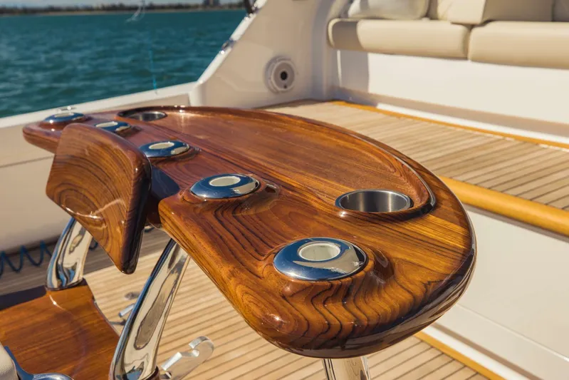 Sari Victoria Yacht Photos Pics Luxurious wooden deck table on a 2020 Viking 72 yacht, overlooking the ocean.
