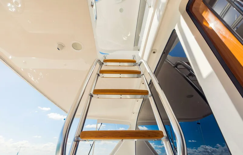Sari Victoria Yacht Photos Pics Staircase on a 2020 Viking 72 yacht, featuring wooden steps and metal railings.