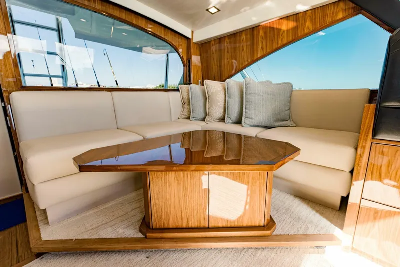 Sari Victoria Yacht Photos Pics Luxurious interior of 2020 Viking 72 yacht with plush seating and elegant wooden table.
