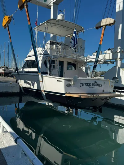 Three Wishes Yacht Photos Pics Bertram 36 SF 2000 yacht "Three Wishes" docked at marina, reflecting in water.